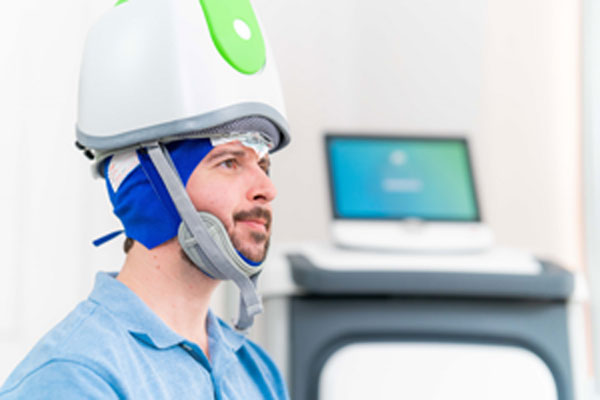 Bild: Die tiefe transkranielle Magnetstimulation (engl. deep TMS – dTMS) ermöglicht es, tiefer gelegene Gehirnregionen und somit mehr Neuronen zu erreichen. ©DGKN/A. Zangen/Brainsway Inc., Jerusalem, Israel. 